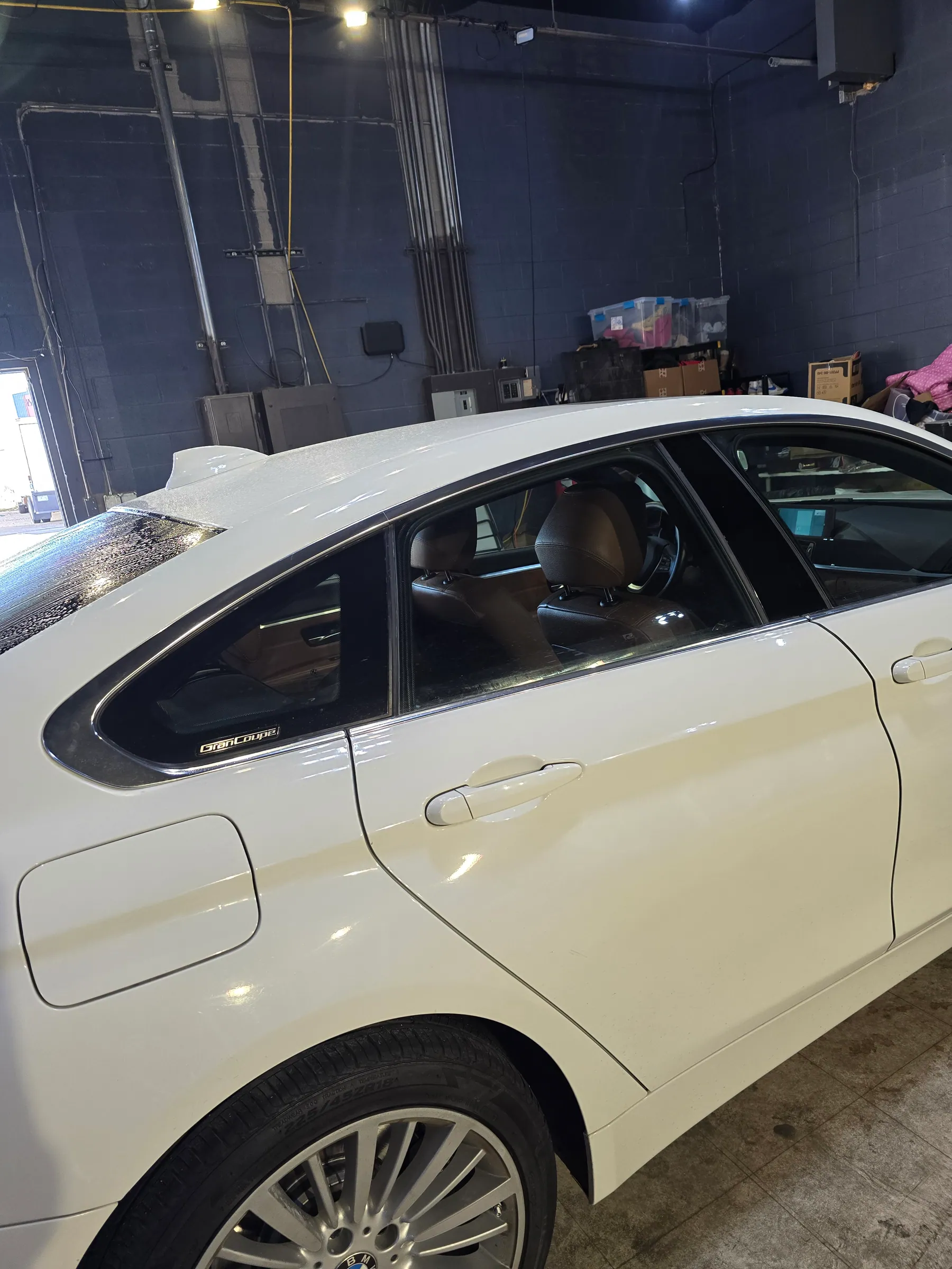 White BMW with reflective paint inside the shop